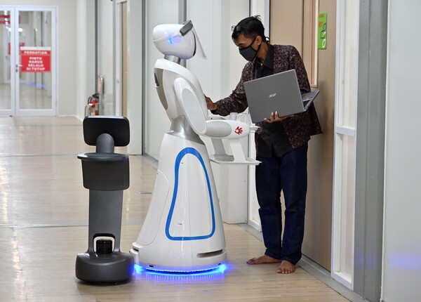 COVID-19를 처리하는 의료팀을 지원하는 시뮬레이션에서  로봇을 검사하는 인도네시아 기술자. (사진=AFP)