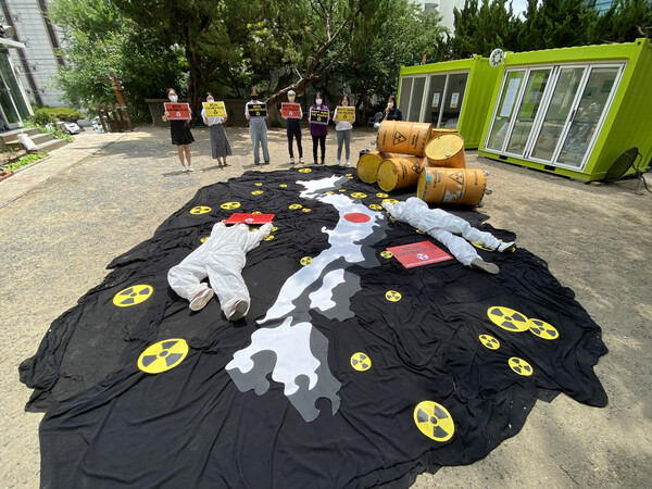 환경단체는 6월8일 일본 지도가 그려진 검은색 바다에 방사능 마크가 뿌려져 있고, 그 위에 방진복을 입은 사람들이 ‘Don’t Nuke The Pacific!’, ‘바다는 쓰레기통이 아니다!’라고 쓰여진 피켓을 들고 누워 다이인 퍼포먼스를 진행했다. (사진=윤미향의원실)