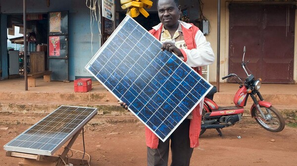 우간다의 한 사업가는 태양광발전용 모듈 판매 사진을 들고 있는 모습.(사진= picturealliance/imageBROKER)