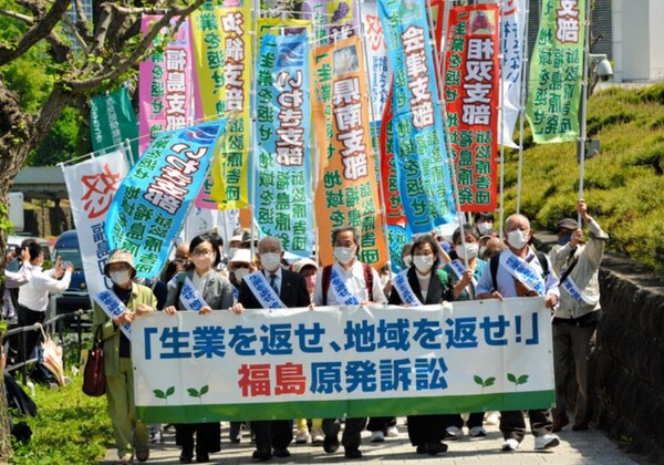 대법원에서의 변론을 앞두고, 현수막을 가지고 행진하는 소송피해자. (사진=2022년 4월 25일 오후 1시 11분, 도쿄도 지요다구, 타키구치 노부유키 촬영 /아사히신문)