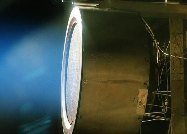 NASA의 제트 추진 연구소에서 테스트 중인 진공 챔버 포트를 통해 촬영된 이 크세논 이온 엔진 이미지는 엔진에서 방출되는 하전 원자의 희미한 푸른 빛을 재현했다.(사진=NASA)