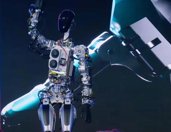 테슬라봇의 코드명인 옵티머스(Optimus)의 첫 번째 프로토타입이 Tesla AI Day 2022 행사에서 팔을 흔들고 있는 모습.(사진=Claire Reilly/CNET의 스크린샷)