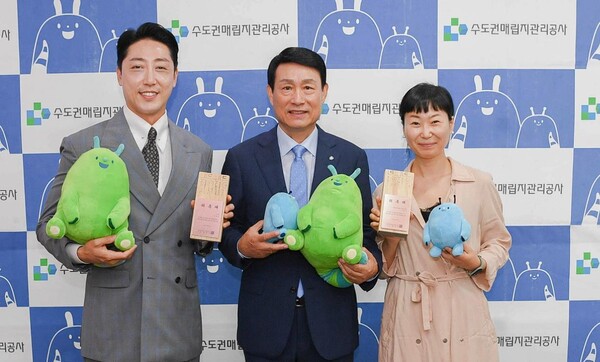 개그맨 손헌수(왼쪽)와 알맹상점 고금숙 대표(오른쪽)가 폐목재로 만든 홍보대사 위촉패를 들고 송병억 수도권매립지관리공사 사장(가운데)과 기념촬영을 하고 있다.