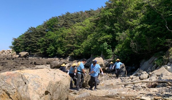 사진=덕적면 북1리 으름실 앞 김진희 덕적면장, 김상훈 환경관리팀장, ㈜안센백신 임직원 30여명이 환경정화활동에 참여하는 모습.