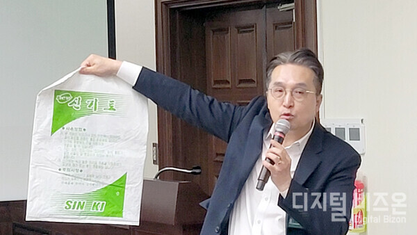 장기석 사무처장이 반려견사료·비료포대 등의 샘플과 시멘트 포대를 비교하며 포대표시의 필요성을 언급하고 있다.