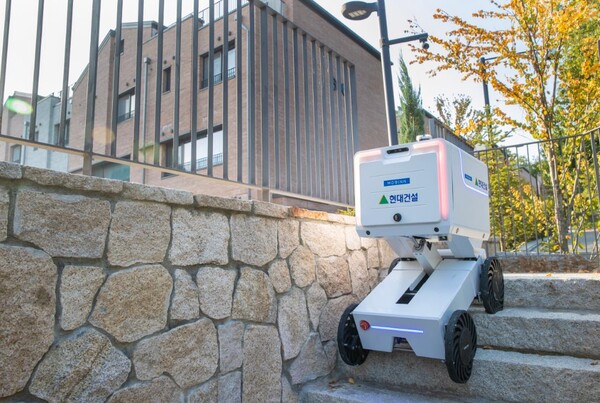 자율주행로봇이 계단을 오르며 단지 내에서 배송 서비스를 운행하고 있다.